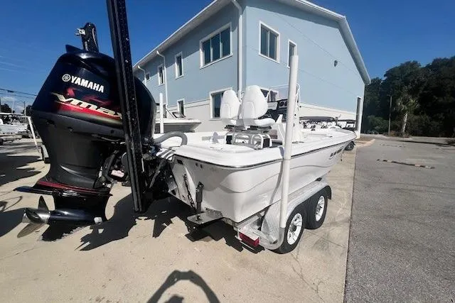 Slide: The Image of 2019 Blue Wave 2200 PureBay boat with Yamaha engine on trailer, parked near a building. - 3