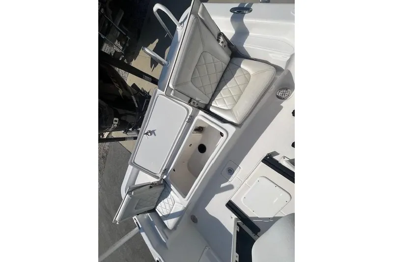 Slide: The Image of 2019 Blue Wave 2200 PureBay boat interior with open storage compartments and cushioned seating. - 5