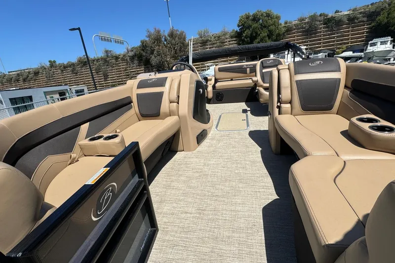 Slide: The Image of 2023 Barletta Cabrio 22UC pontoon boat interior with tan seating and cup holders. - 16