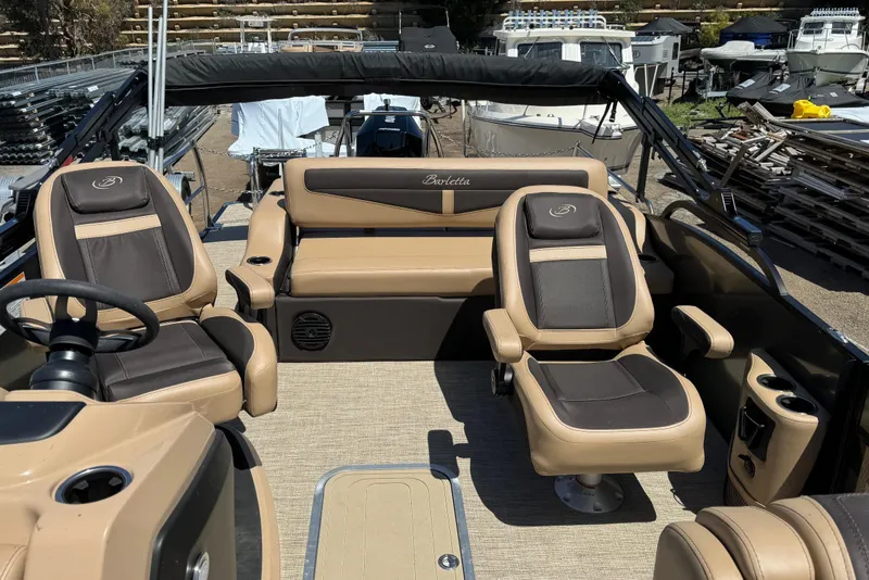 Slide: The Image of 2023 Barletta Cabrio 22UC interior with tan and brown seating, steering wheel, and cup holders. - 21