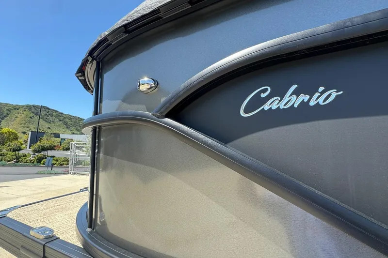 Slide: The Image of 2023 Barletta Cabrio 22UC boat exterior with logo, set against a scenic backdrop. - 3