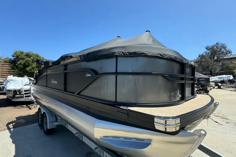 Slide: The Image of 2023 Barletta Cabrio 22UC pontoon boat on trailer, covered and parked outdoors. - 6