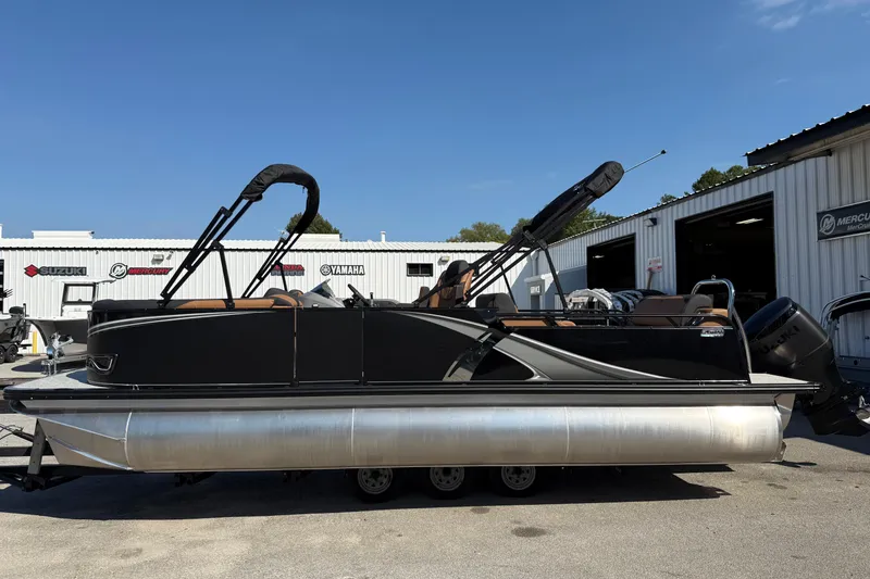 Slide: The Image of 2026 Tahoe Pontoon LTZ Versatile Rear Lounger, silver exterior, parked outdoors. - 2