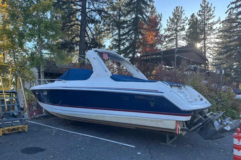 The Image of 2004 Formula 330 Sun Sport boat parked outdoors among trees. - 0