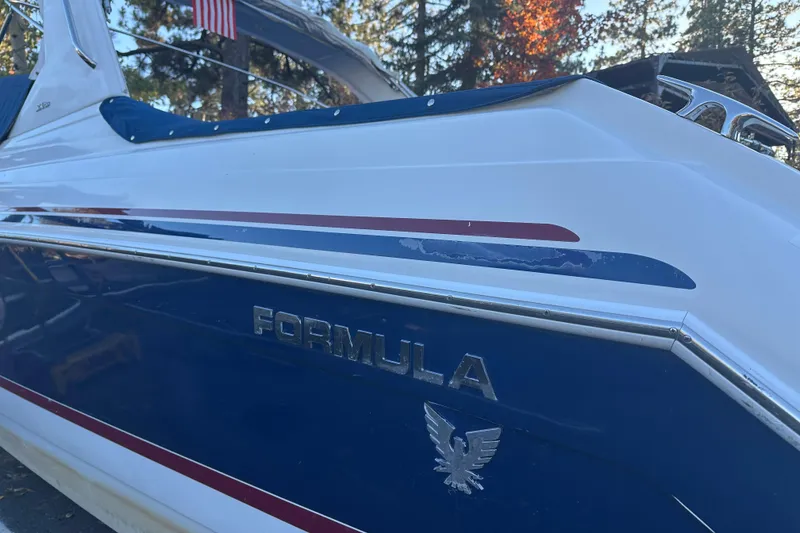 Slide: The Image of 2004 Formula 330 Sun Sport boat with blue and white exterior, docked outdoors. - 2
