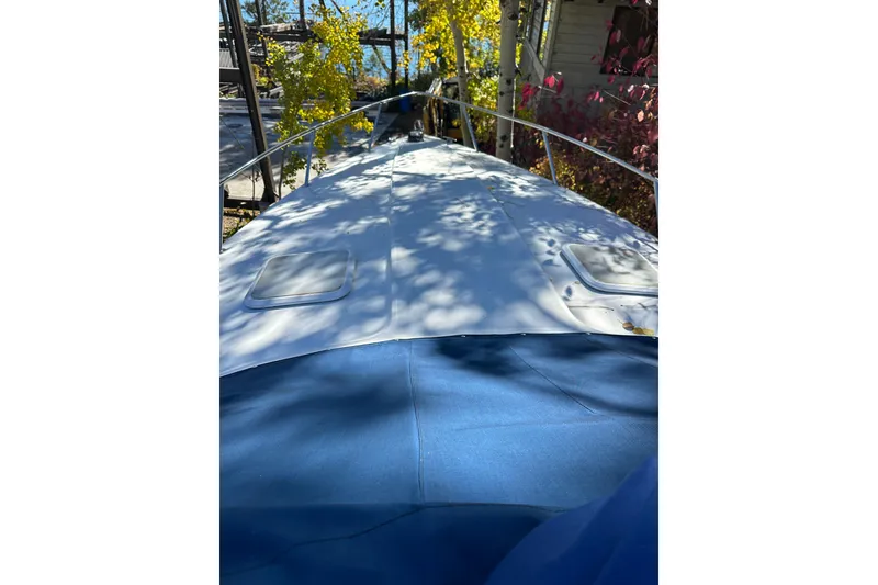 Slide: The Image of 2004 Formula 330 Sun Sport boat with blue cover, docked near trees. - 4