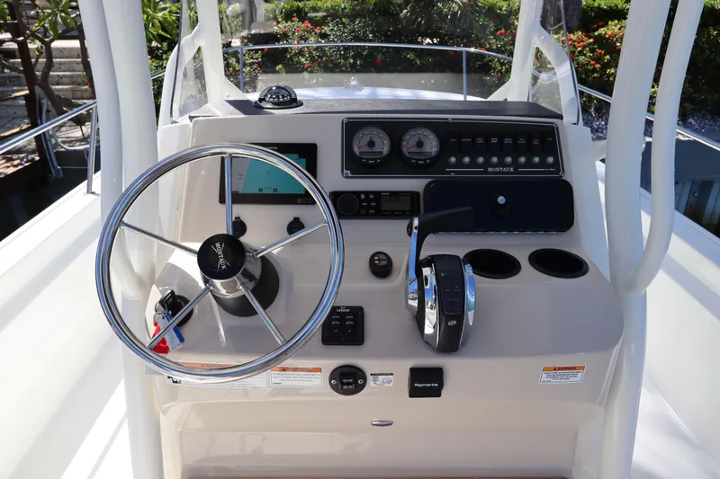 Slide: The Image of 2019 Boston Whaler 210 Montauk boat dashboard with steering wheel and controls. - 15