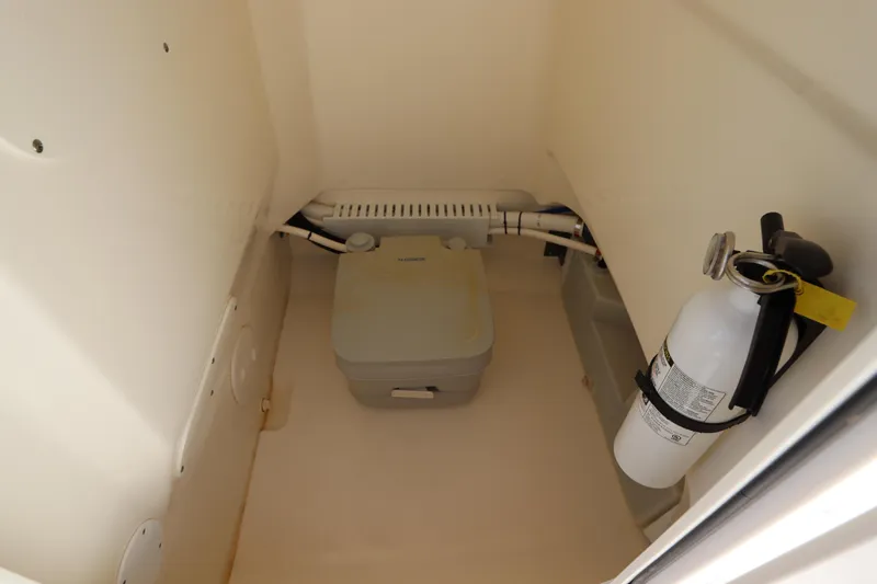 Slide: The Image of 2019 Boston Whaler 210 Montauk interior with portable toilet and fire extinguisher. - 26