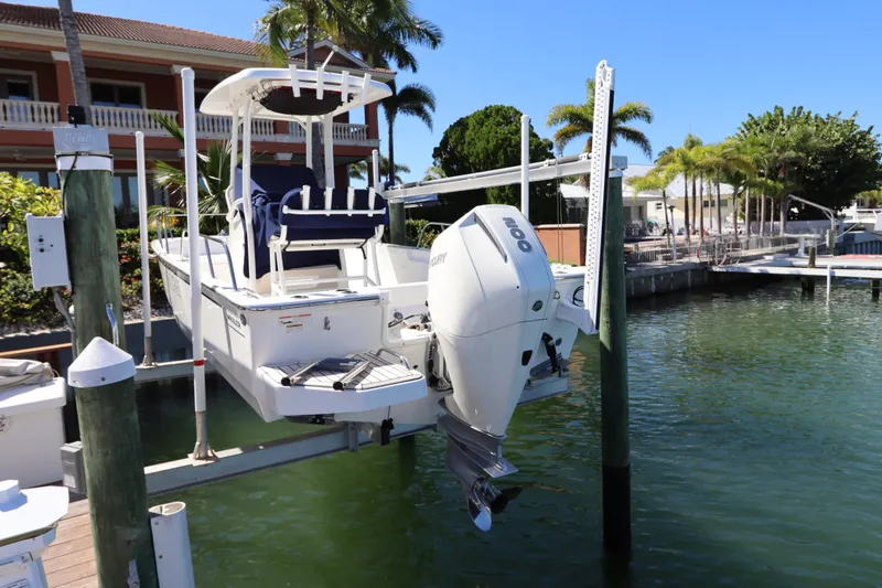 Slide: The Image of 2019 Boston Whaler 210 Montauk boat docked by waterfront home with palm trees. - 3