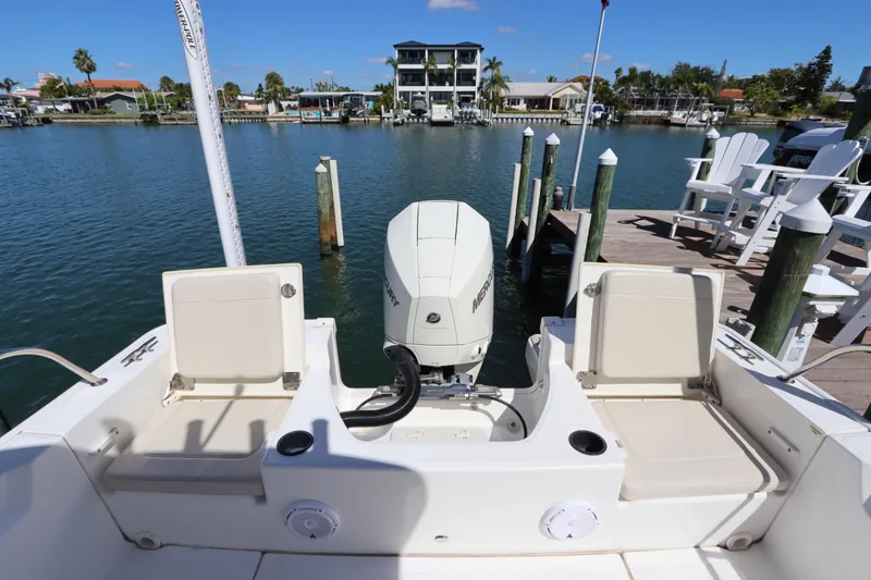 Slide: The Image of 2019 Boston Whaler 210 Montauk boat docked, featuring Mercury outboard motor. - 8