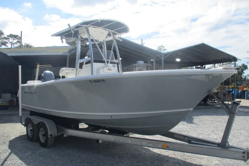 Slide: The Image of 2015 Sea Hunt Triton 225 boat on trailer, parked outdoors under a clear sky. - 4