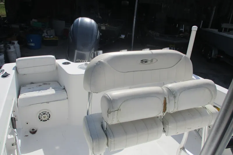 Slide: The Image of 2015 Sea Hunt Triton 225 boat interior with white seating and motor. - 8
