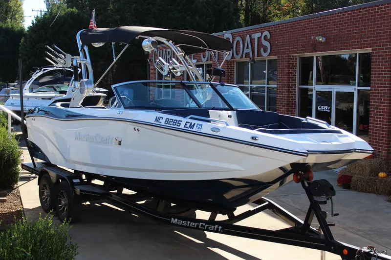 The Image of 2019 MasterCraft XT22 boat on trailer outside dealership. - 1