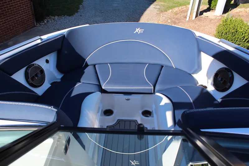 Slide: The Image of 2019 MasterCraft XT22 boat interior with blue seating and built-in speakers. - 12