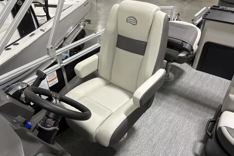 Slide: The Image of 2026 Sun Tracker Fishin' Barge 22 DLX interior seating, featuring gray and beige upholstery. - 21