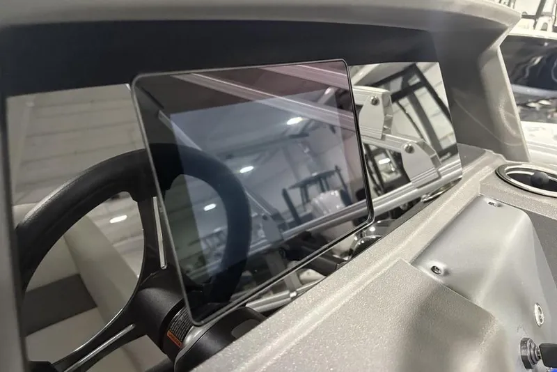 Slide: The Image of 2026 Sun Tracker Fishin' Barge 22 DLX dashboard with steering wheel and controls. - 23