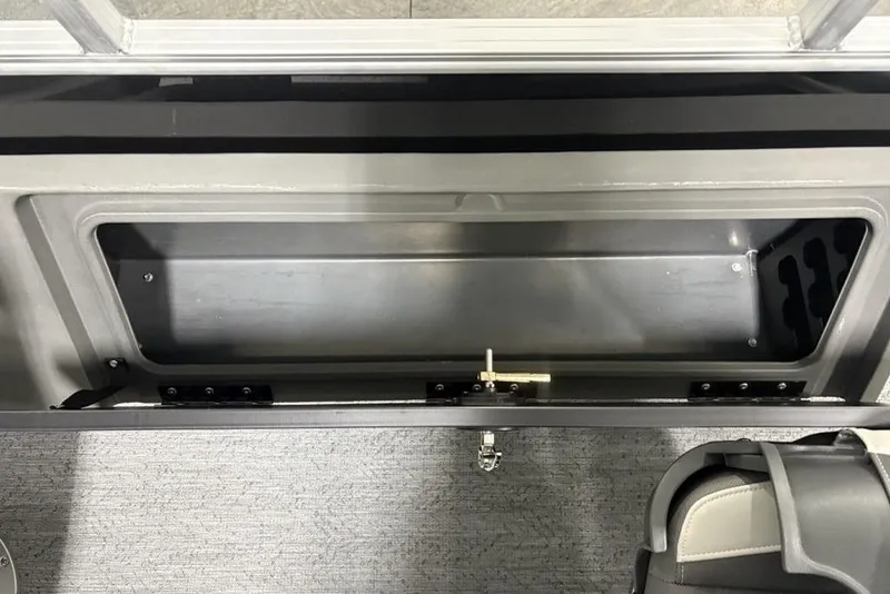 Slide: The Image of 2026 Sun Tracker Fishin' Barge 22 DLX storage compartment with secure latch and seating. - 32