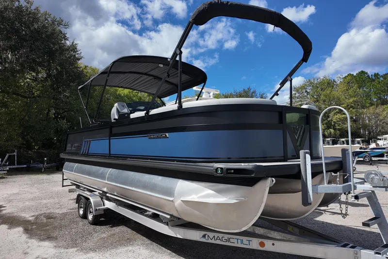 Slide: The Image of 2026 Viaggio Diamante 24S pontoon boat on trailer under blue sky. - 2