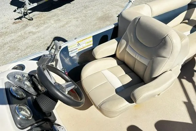 Slide: The Image of 2016 Godfrey Sweetwater 2286 Pontoon boat interior with steering wheel and beige captain's chair. - 7