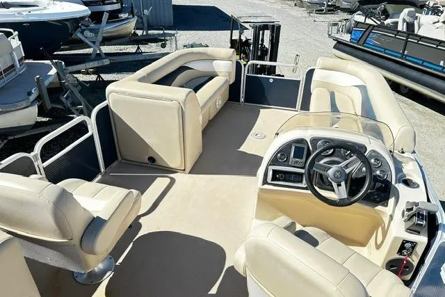 Slide: The Image of 2016 Godfrey Sweetwater 2286 Pontoon boat interior with beige seating and steering console. - 8