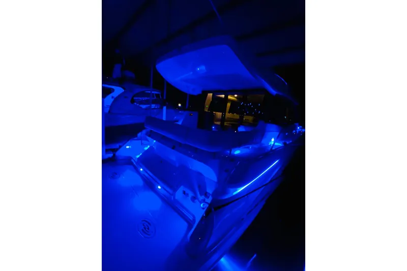 Slide: The Image of 2018 Regal 42 Grande Coupe yacht illuminated with blue LED lights at night. - 22