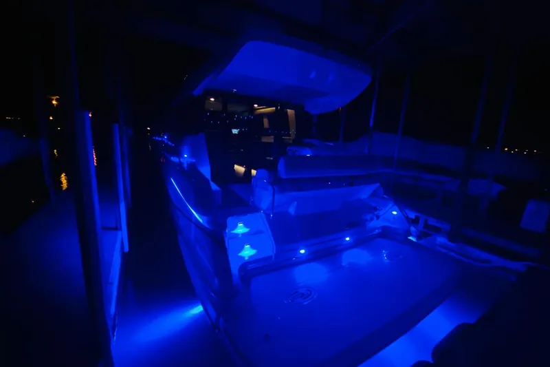 Slide: The Image of 2018 Regal 42 Grande Coupe yacht illuminated with blue LED lights at night. - 23