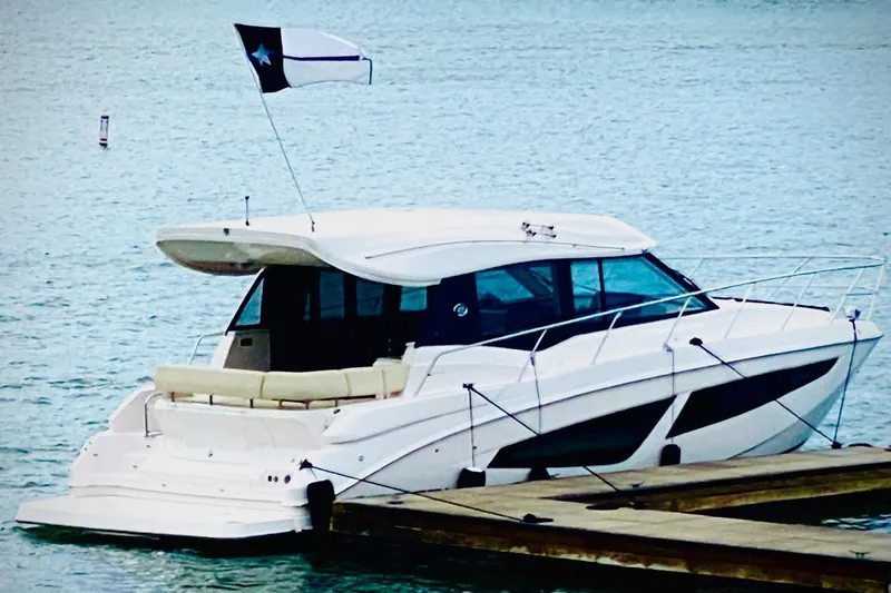 Slide: The Image of 2018 Regal 42 Grande Coupe yacht docked on calm water. - 24