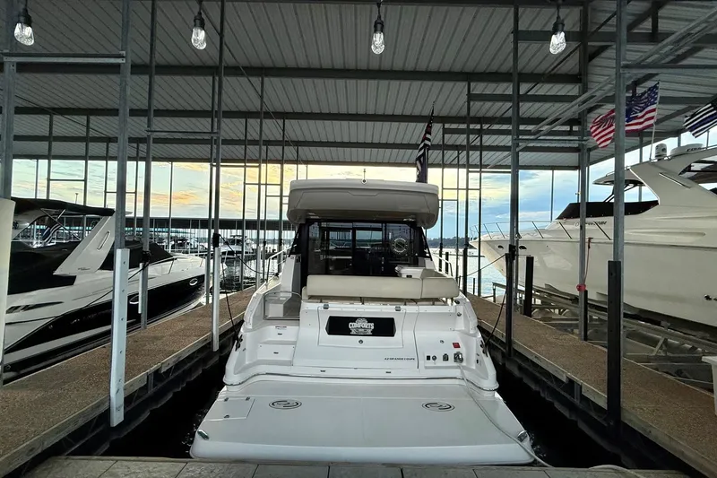 Slide: The Image of 2018 Regal 42 Grande Coupe docked under a covered marina with scenic water view. - 3