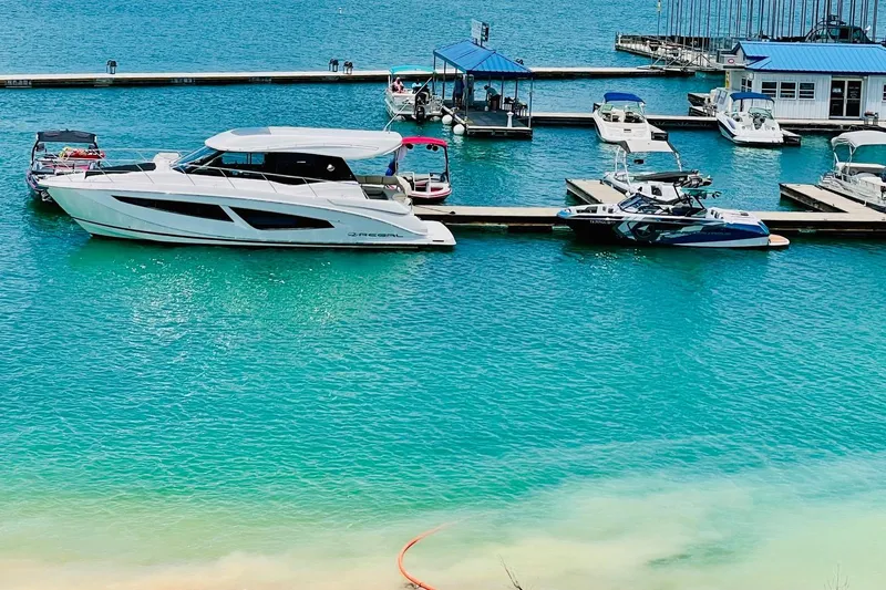 Slide: The Image of 2018 Regal 42 Grande Coupe docked in a vibrant marina setting. - 31