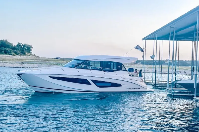 Slide: The Image of 2018 Regal 42 Grande Coupe yacht docked on serene water. - 32
