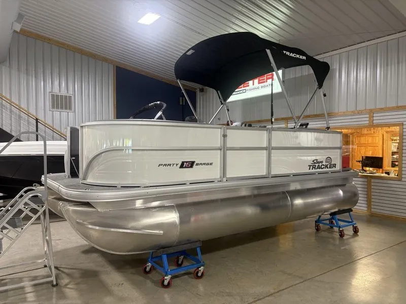 Slide: The Image of 2026 Sun Tracker PARTY BARGE® 16 DLX pontoon boat displayed indoors. - 6