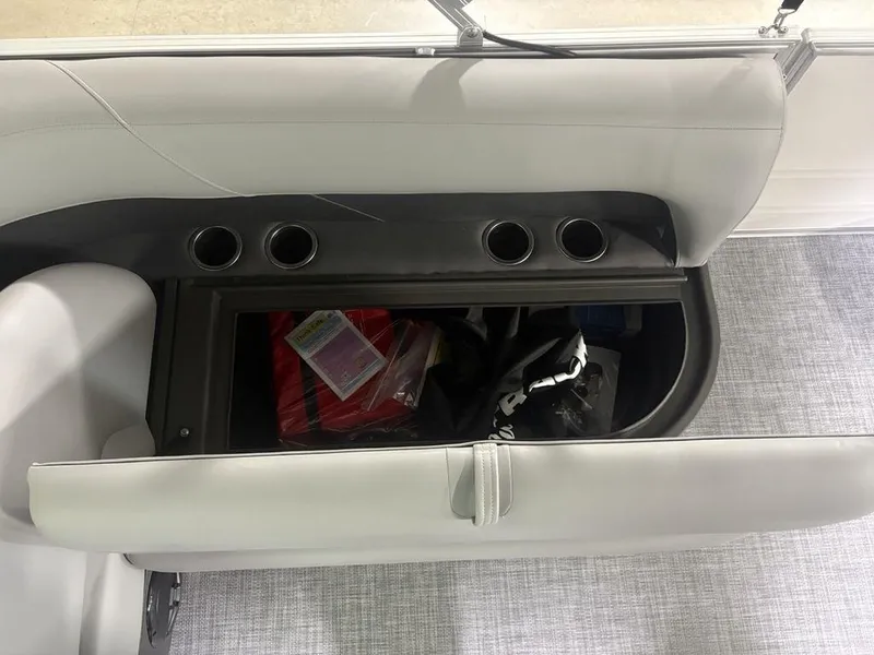 Slide: The Image of 2026 Sun Tracker PARTY BARGE® 16 DLX storage compartment with cup holders and interior items. - 9