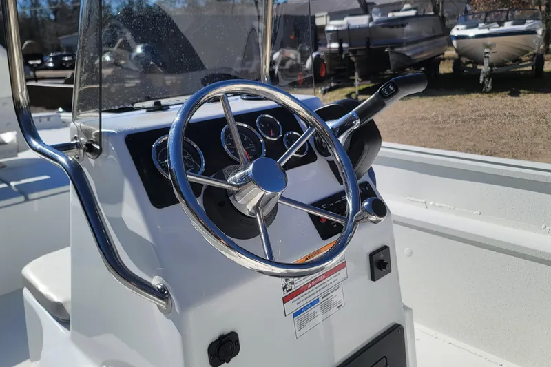 Slide: The Image of Steering console of 2026 G3 Bay 20 boat with chrome details and gauges. - 14