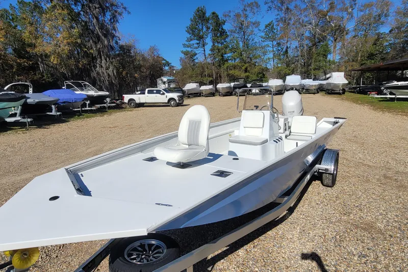 Slide: The Image of 2026 G3 Bay 20 boat on trailer in outdoor showroom, surrounded by trees and other boats. - 18