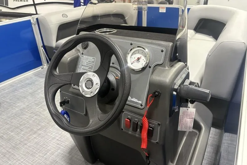 Slide: The Image of 2026 Sun Tracker Party Barge 16 DLX steering console with gauge and controls. - 18