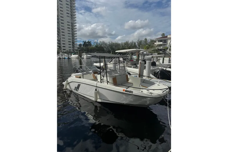 Slide: The Image of 2024 Beneteau Flyer 7 SPACEdeck boat docked in a marina under a cloudy sky. - 2