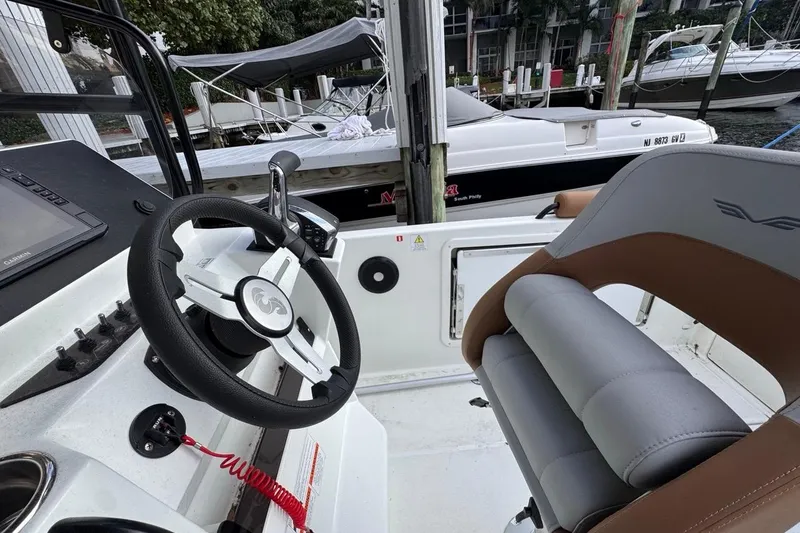 Slide: The Image of 2024 Beneteau Flyer 7 SPACEdeck cockpit with steering wheel and controls, docked at marina. - 25