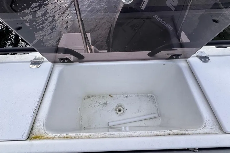 Slide: The Image of 2024 Beneteau Flyer 7 SPACEdeck boat storage compartment with open lid and visible drain. - 28