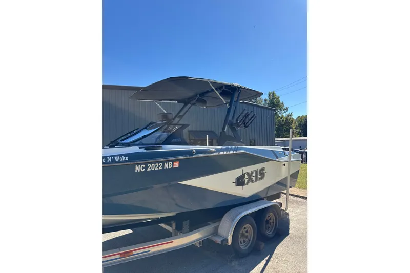 Slide: The Image of 2023 Axis T220 boat on trailer, parked outdoors under clear blue sky. - 19