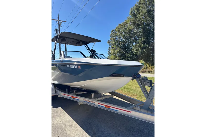 Slide: The Image of 2023 Axis T220 boat on trailer, parked outdoors under clear blue sky. - 20