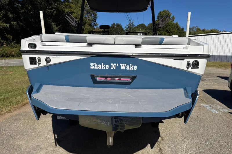 Slide: The Image of 2023 Axis T220 boat on trailer, parked outdoors under clear blue sky. - 24