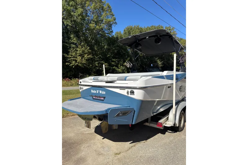 Slide: The Image of 2023 Axis T220 boat named "Shake N' Wake" with blue and white design. - 25