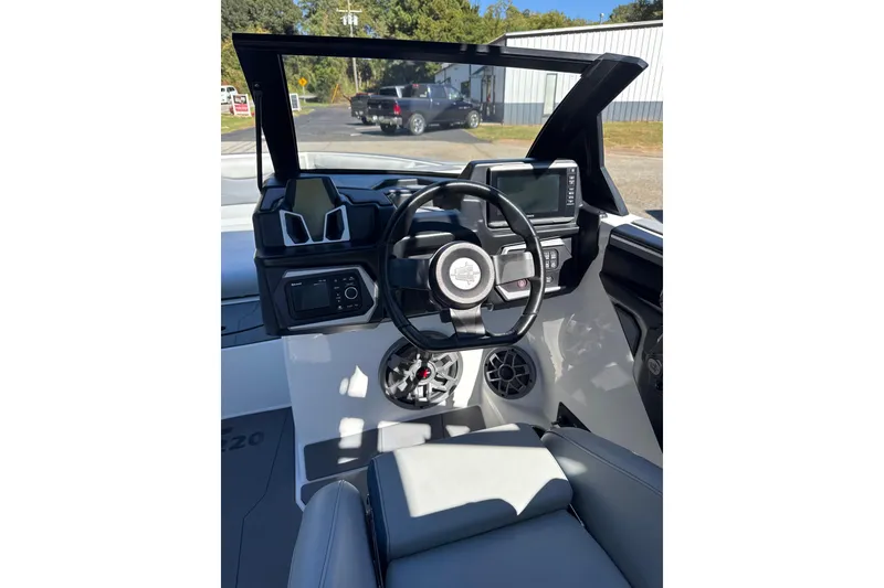 Slide: The Image of 2023 Axis T220 boat with sleek seating and canopy, parked outdoors. - 6