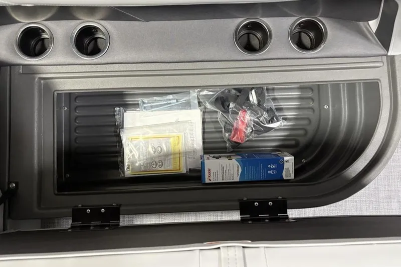 Slide: The Image of Storage compartment of 2026 Sun Tracker Party Barge 16 DLX with accessories and cup holders. - 17