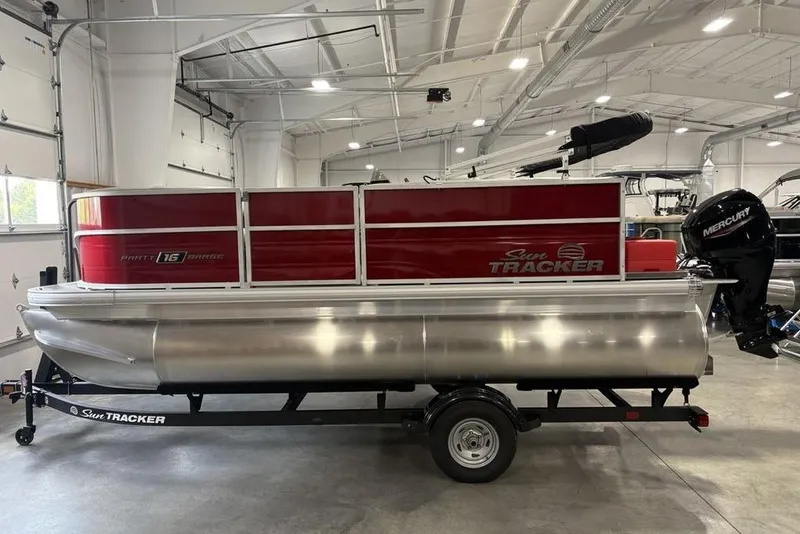 The Image of 2026 Sun Tracker Party Barge 16 DLX pontoon boat in a showroom. - 2