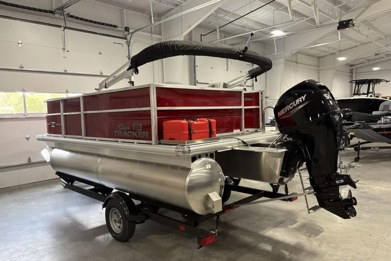 Slide: The Image of 2026 Sun Tracker Party Barge 16 DLX pontoon boat with Mercury engine in a garage. - 4