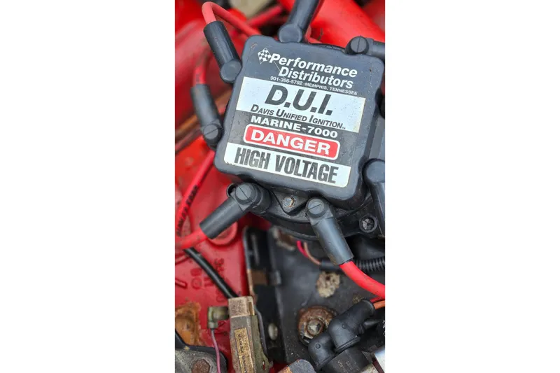 Slide: The Image of Engine compartment of a 1987 Rampage 28 Sportsman boat, showcasing red engine components. - 48