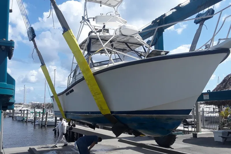 Slide: The Image of 1987 Rampage 28 Sportsman boat docked near lush greenery and buildings. - 5
