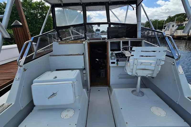 Slide: The Image of 1987 Rampage 28 Sportsman boat with metal ladder and dock view. - 7