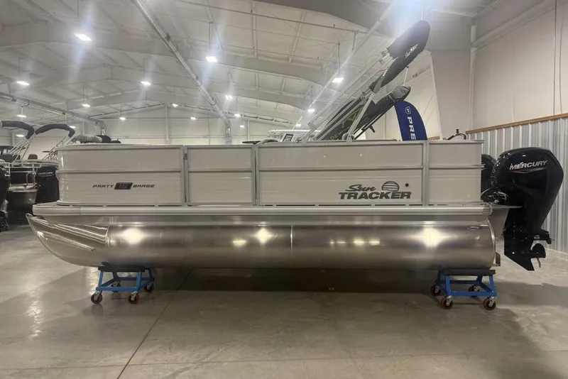 The Image of 2026 Sun Tracker Party Barge 18 DLX pontoon boat in showroom, side view. - 1